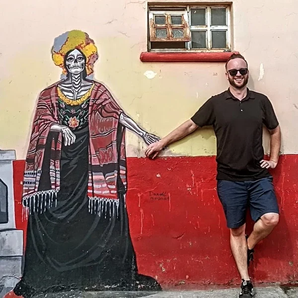 Traveler holding hands with a Catrina figure during Day of the Dead ,in Mexico