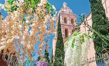 View of Atlixco’s parish church surrounded by festive floral decorations, capturing the colorful spirit of the Magic Town’s garden-filled streets.