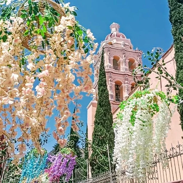 View of Atlixco’s parish church surrounded by festive floral decorations, capturing the colorful spirit of the Magic Town’s garden-filled streets.