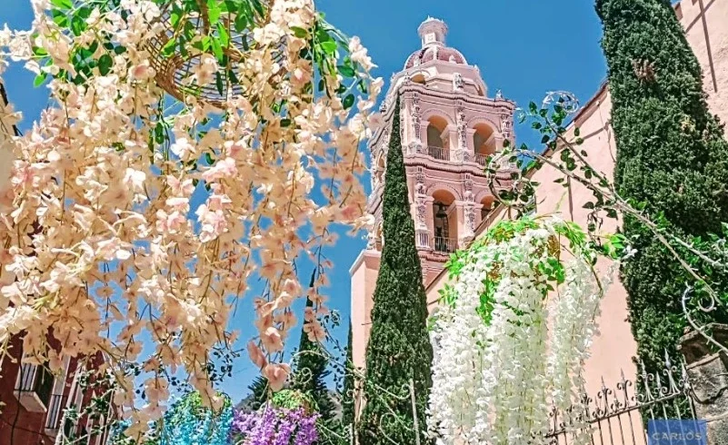 View of Atlixco’s parish church surrounded by festive floral decorations, capturing the colorful spirit of the Magic Town’s garden-filled streets.