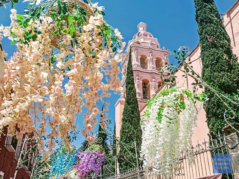 View of Atlixco’s parish church surrounded by festive floral decorations, capturing the colorful spirit of the Magic Town’s garden-filled streets.