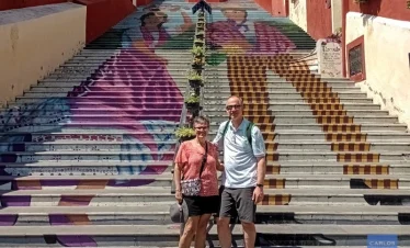 alt="Iconic staircase in Atlixco decorated with colorful murals of local characters, celebrating the town’s artistic identity and community heritage.