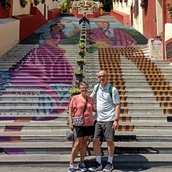 alt="Iconic staircase in Atlixco decorated with colorful murals of local characters, celebrating the town’s artistic identity and community heritage.