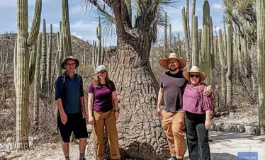 alt="Friends posing beside a centuries-old endemic cactus in the Cuicatlán–Tehuacán Biosphere Reserve, celebrating Mexico’s desert biodiversity.