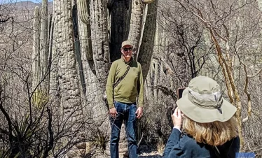 Couple photographing one of the iconic columnar cacti in the Cuicatlán–Tehuacán Biosphere Reserve, capturing Mexico’s unique desert flora.