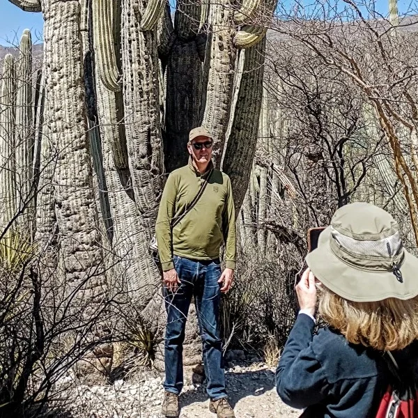 Couple photographing one of the iconic columnar cacti in the Cuicatlán–Tehuacán Biosphere Reserve, capturing Mexico’s unique desert flora.