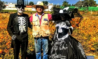 Couple dressed as Catrines with tour guide Carlos Rivero in a cempaxóchitl field near Puebla.