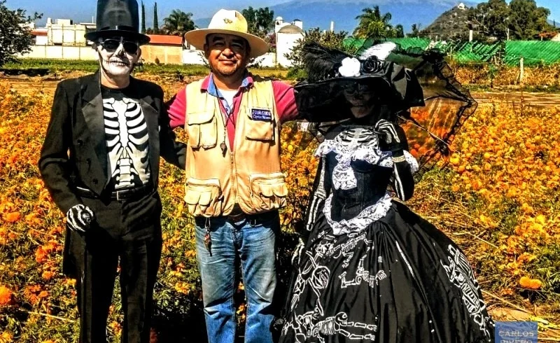 Couple dressed as Catrines with tour guide Carlos Rivero in a cempaxóchitl field near Puebla.