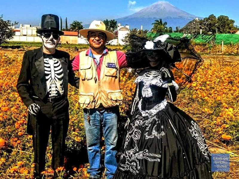 Couple dressed as Catrines with tour guide Carlos Rivero in a cempaxóchitl field near Puebla.