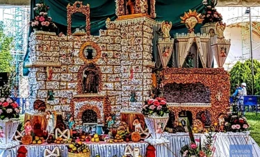 Day of the Dead altar in Huaquechula honoring local artist Nachito – traditional multi-tier tribute with candles, flowers, and personal memorabilia.