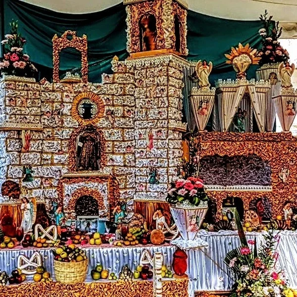 Day of the Dead altar in Huaquechula honoring local artist Nachito – traditional multi-tier tribute with candles, flowers, and personal memorabilia.