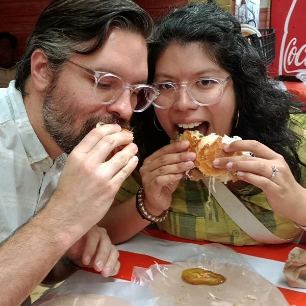 Couple enjoying one of Puebla’s most iconic street food specialties during a walking tour in the historic center, savoring traditional flavors and local atmosphere.
