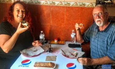 Two friends enjoying another classic Puebla street food specialty during the walking tour, sharing authentic flavors and cultural moments in the historic center.
