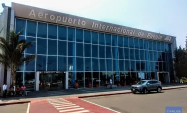 Facade of Puebla International Airport (PBC) – pick-up zone for private city-to-airport transfers.
