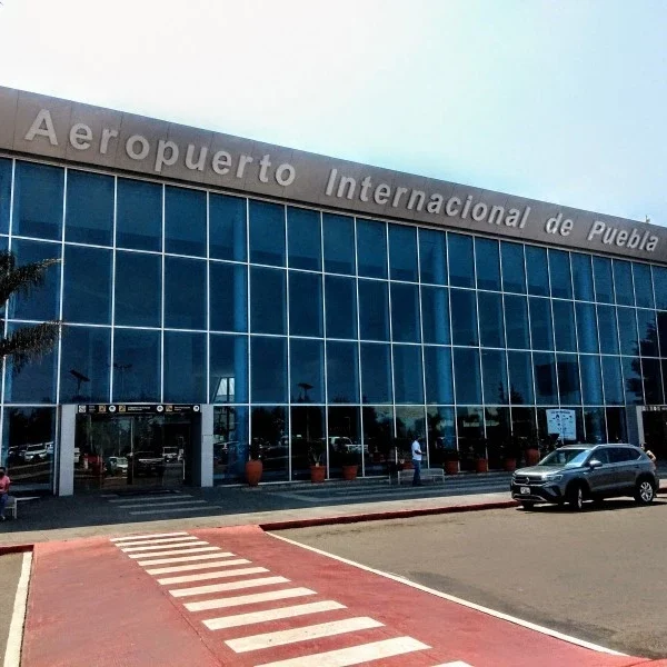 Facade of Puebla International Airport (PBC) – pick-up zone for private city-to-airport transfers.