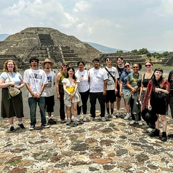 Group of young travelers admiring the view of the Pyramid of the Moon at Teotihuacan, immersed in the ancient atmosphere of Mexico’s iconic archaeological site.