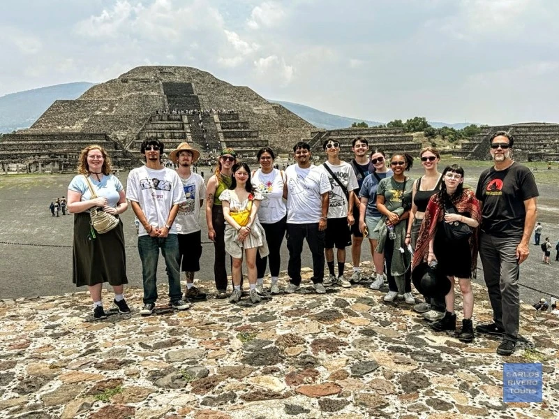 Group of young travelers admiring the view of the Pyramid of the Moon at Teotihuacan, immersed in the ancient atmosphere of Mexico’s iconic archaeological site.