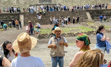 alt="Cultural guide explaining the Avenue of the Dead at Teotihuacan, sharing insights into ancient ceremonial routes and Mesoamerican urban design.