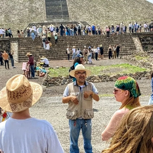 alt="Cultural guide explaining the Avenue of the Dead at Teotihuacan, sharing insights into ancient ceremonial routes and Mesoamerican urban design.