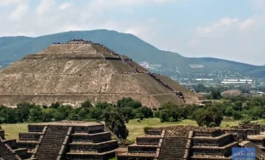 Panoramic view of the Pyramid of the Sun alongside smaller pyramids at Teotihuacan, showcasing ancient Mesoamerican architecture under the open sky.