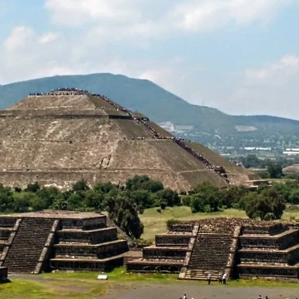 Panoramic view of the Pyramid of the Sun alongside smaller pyramids at Teotihuacan, showcasing ancient Mesoamerican architecture under the open sky.