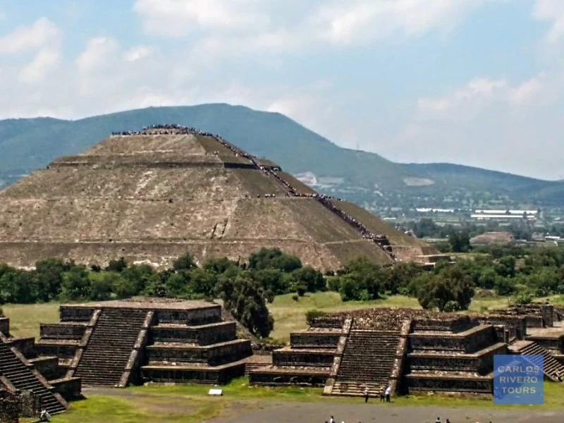 Panoramic view of the Pyramid of the Sun alongside smaller pyramids at Teotihuacan, showcasing ancient Mesoamerican architecture under the open sky.