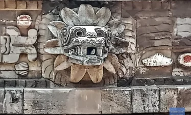 Stone-carved head of the feathered serpent emerging from the Pyramid of the Feathered Serpent at Teotihuacan, symbolizing ancient Mesoamerican mythology and architectural mastery.