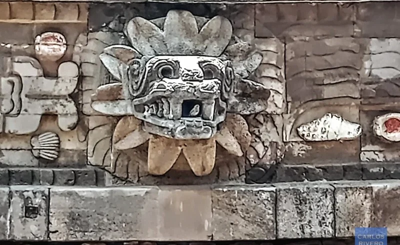 Stone-carved head of the feathered serpent emerging from the Pyramid of the Feathered Serpent at Teotihuacan, symbolizing ancient Mesoamerican mythology and architectural mastery.