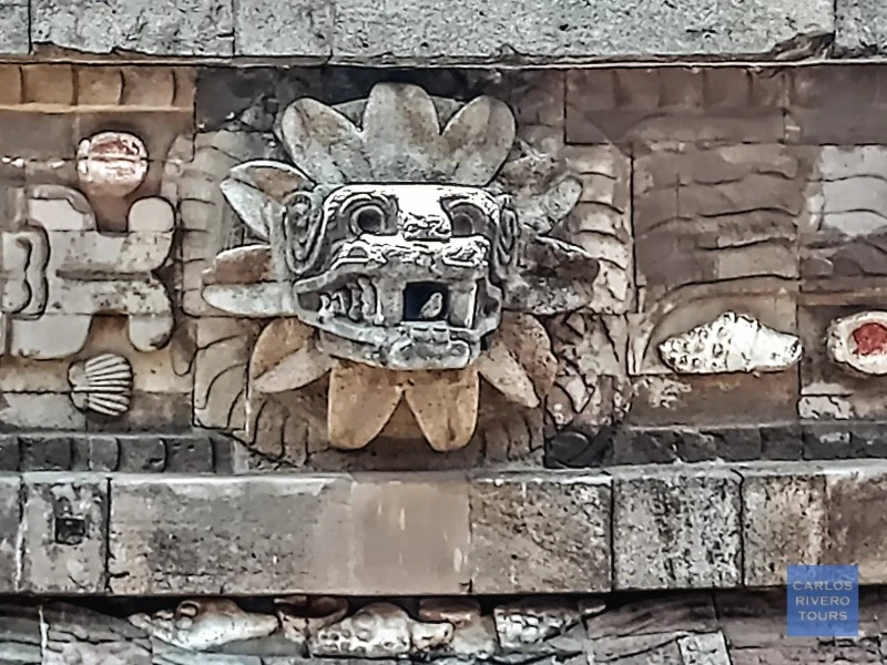 Stone-carved head of the feathered serpent emerging from the Pyramid of the Feathered Serpent at Teotihuacan, symbolizing ancient Mesoamerican mythology and architectural mastery.