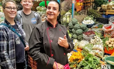 “Culinary guide leading visitors through Puebla market – cultural tour highlighting local ingredients, flavors, and Mexican gastronomic traditions.