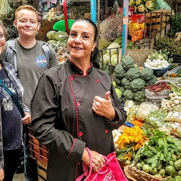 “Culinary guide leading visitors through Puebla market – cultural tour highlighting local ingredients, flavors, and Mexican gastronomic traditions.