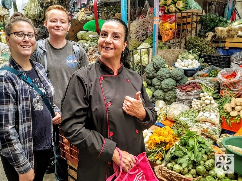 “Culinary guide leading visitors through Puebla market – cultural tour highlighting local ingredients, flavors, and Mexican gastronomic traditions.